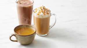A small glass of bone broth beside a whipped-cream latte and a milkshake, showing its low calories
