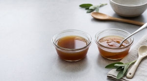 Two dishes of bone broth side by side, one liquid and one set into a firm collagen gel